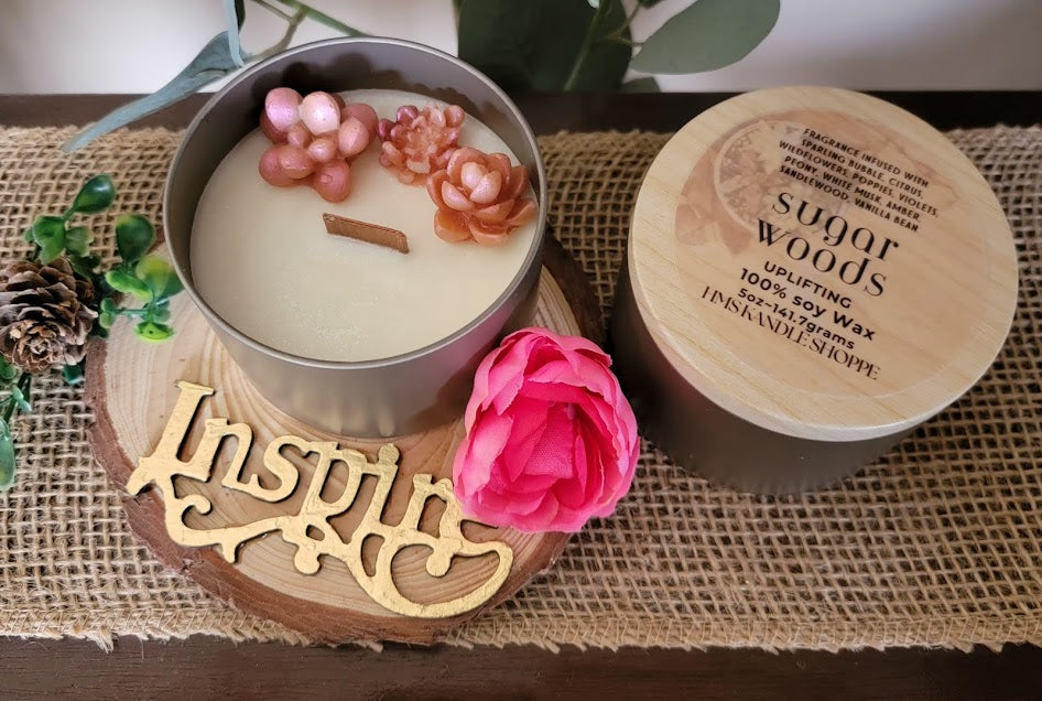 sugar woods-Uplifting Spiritual Kandle

5oz ~ 141.7 Champagne Gold Metal Tin, Faux woodgrain lid - 100% Soy Wax

This beautiful kandle is a classic white kandle with shimmering rosey succulents and a crackling wood wick.

This fragrance is infused with sparkling bubbles, citrus, wildflowers, poppies, violets, peony, white musk, amber, sandalwood and vanilla bean. This fragrance is a light and fun. It will elevate your mood.

Succulents represent enduring, timeless love, and adaptability, reminding us to ove