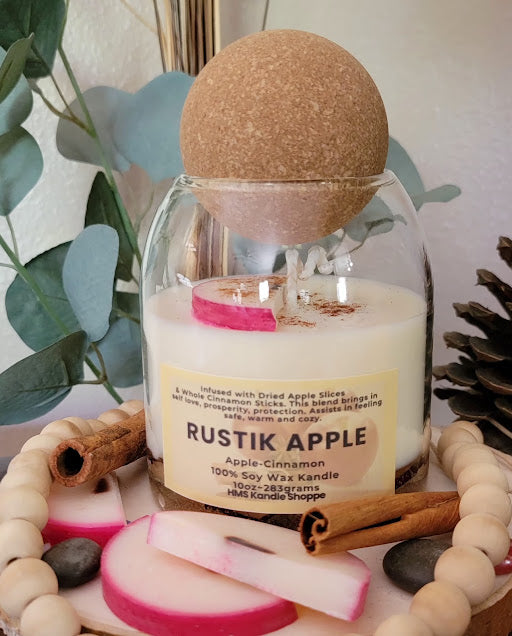 Rustik Apple Kandle-Spiritual

10oz Glass Jar with Ball Cork Lid

10oz~283grams 100% Soy Wax

Apple-Cinnamon&nbsp;

Infused with Dried Apple Slices&nbsp;&amp; Whole Cinnamon Sticks. This blend brings in self love, prosperity, protection. Assists in feeling safe, warm and cozy. Also a fun apple wax melt on top with a sprinkle of cinnamon.

The dried herbs are uniquely placed in the bottom of the jar set in a clear bubbly gel wax. The cotton wick is intentionally placed on top of the gel wax so that all of th