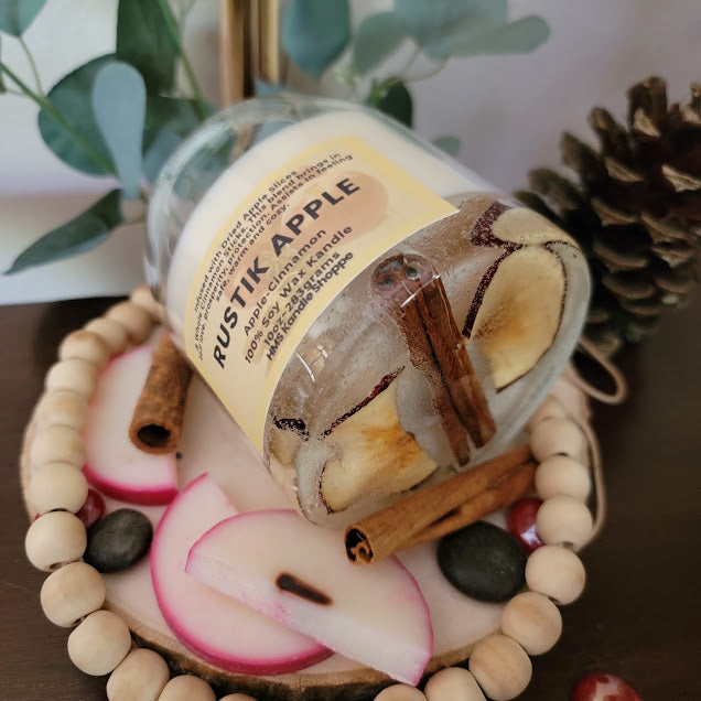Rustik Apple Kandle-Spiritual

10oz Glass Jar with Ball Cork Lid

10oz~283grams 100% Soy Wax

Apple-Cinnamon&nbsp;

Infused with Dried Apple Slices&nbsp;&amp; Whole Cinnamon Sticks. This blend brings in self love, prosperity, protection. Assists in feeling safe, warm and cozy. Also a fun apple wax melt on top with a sprinkle of cinnamon.

The dried herbs are uniquely placed in the bottom of the jar set in a clear bubbly gel wax. The cotton wick is intentionally placed on top of the gel wax so that all of th