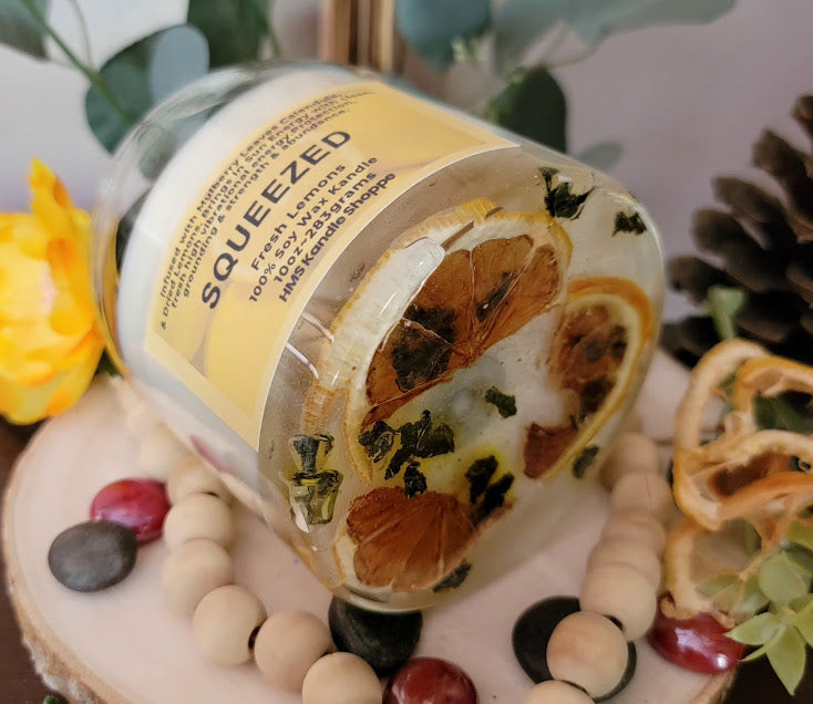 Squeezed Kandle-Spiritual

10oz Glass Jar with Ball Cork Lid

10oz~283grams 100% Soy Wax

Fresh Lemons

Infused with Mulberry Leaves &amp; Dried Lemons. Brings in Sun Energy with clean, fresh high vibrational energy. Protection, grounding &amp; strength &amp; abundance. A fun lemon wedge on top of kandle.

The dried herbs are uniquely placed in the bottom of the jar set in a clear bubbly gel wax. The cotton wick is intentionally placed on top of the gel wax so that all of the natural elements are kept below