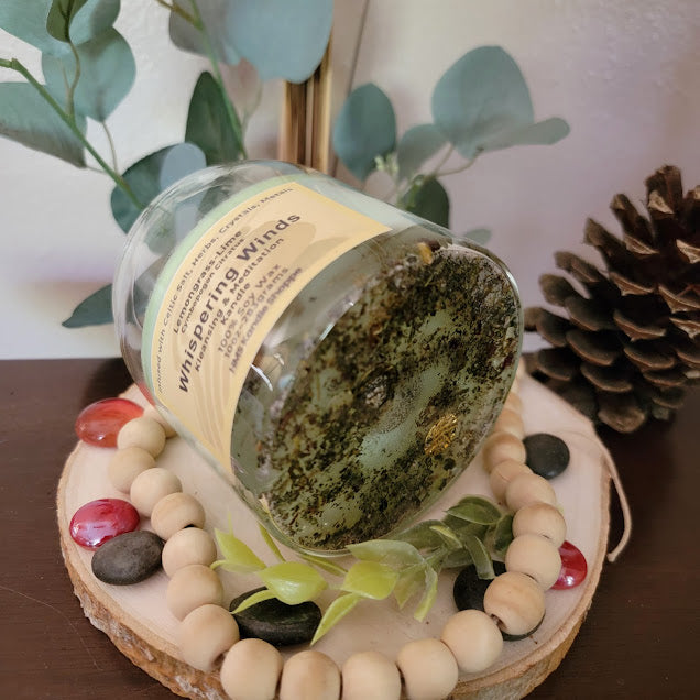 Whispering Winds- Kleansing Meditation Kandle

10oz Glass Jar with Ball Cork Lid

Fresh Lemongrass &amp; Lime Meditation Whispering Winds Intention kandles are made of 100% soy wax with a fresh, clean lemongrass-lime fragrance. This kandle is a great tool to use during meditation. The combination of herbs, salts, crystals and metals assist in clearing energy and bring you to a calm state of mind.

The dried herbs, salt, crystals and coins are uniquely placed in the bottom of the jar set in a cl
